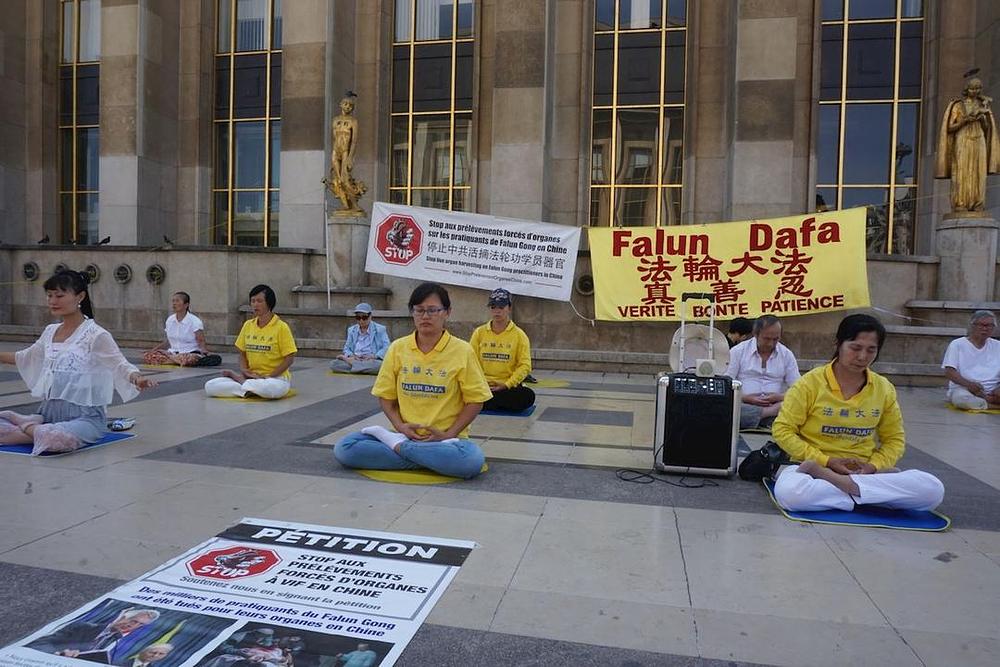 Falun Gong praktikanti na trgu Trocadéro demonstriraju izvođenje vježbi.