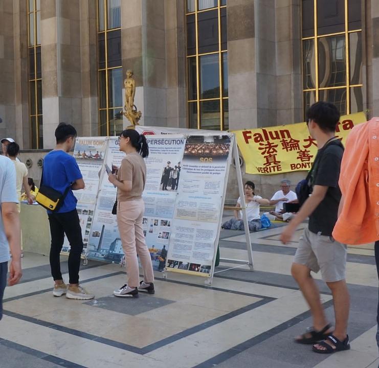 Kineski turisti razgovaraju sa praktikantima o Falun Gongu.