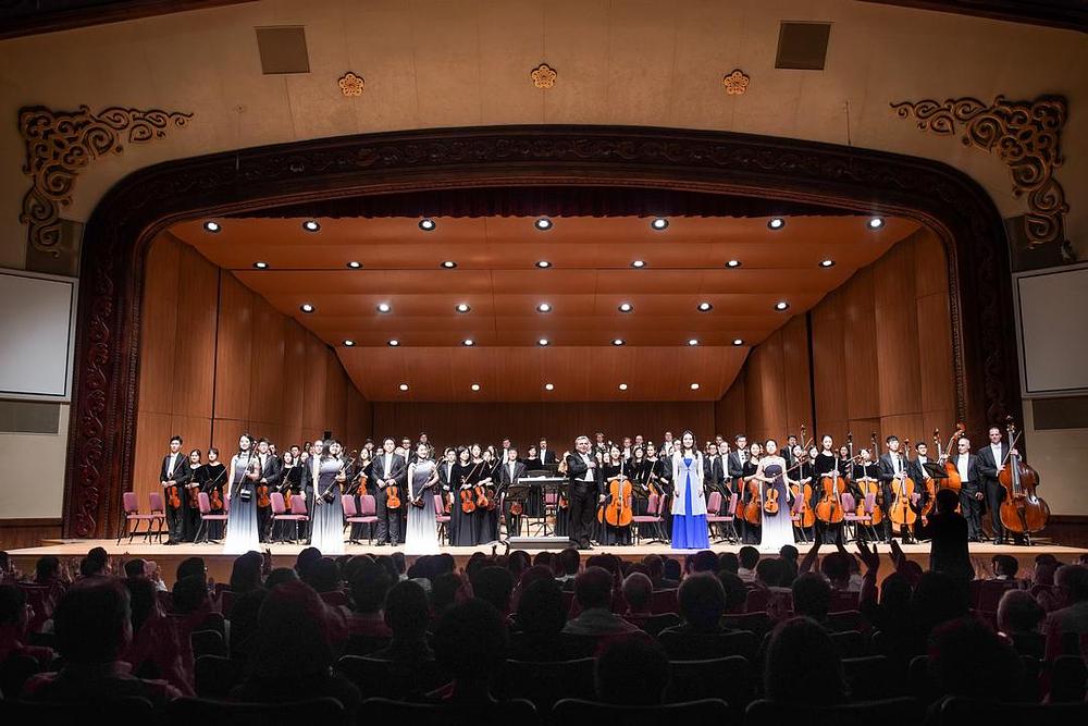 Poziv članovima Simfonijskog orkestra Shen Yun da izađu pred pozorišnu zavjesu.