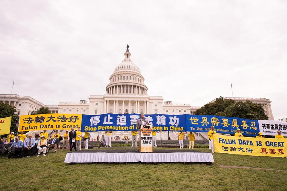Skup na Zapadnom travnjaku SAD Kapitola 20. juna 2018. godine. Praktikanti drže transparente koji pozivaju na okončanje progona i podizanje svijesti o opasnostima komunizma 
