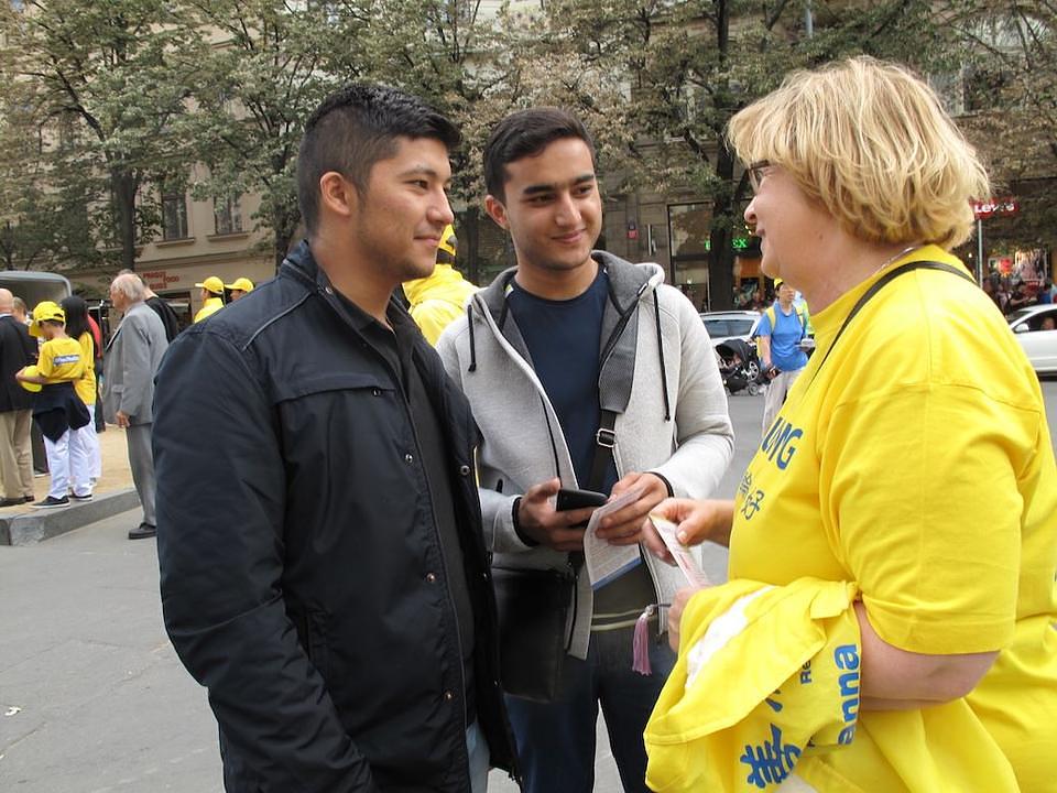  Dvoje je mladih slušaju praktikanticu koja im je predstavila Falun Gong