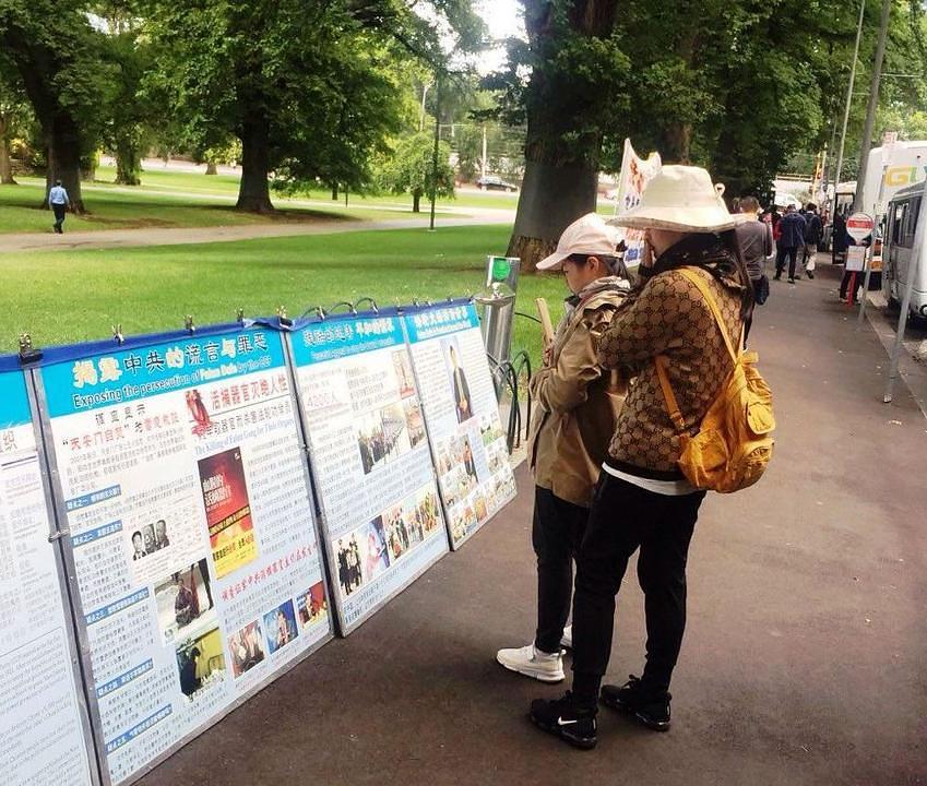 Februar 2019. - Kineski turisti čitaju o progonu Falun Gonga na plakatima postavljenim na ulazu u Fitzroy Gardens u Melbournu. 
 