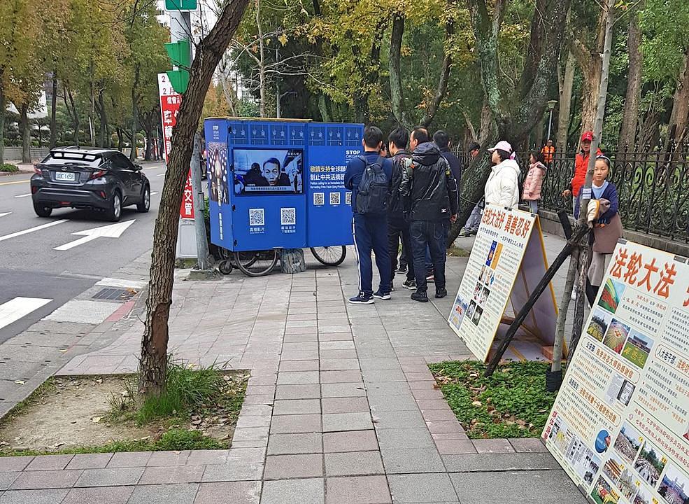 Kineski turisti gledaju plakate i video materijale 