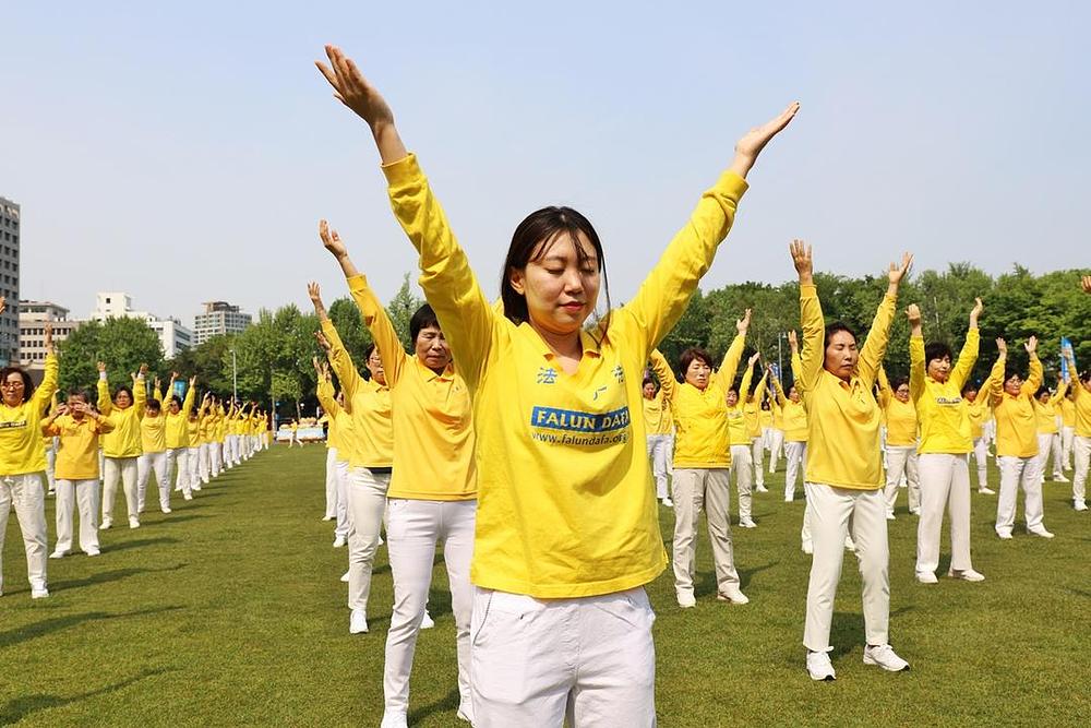 Praktikanti na trgu Seoul Plaza grupno prakticiraju Falun Dafa vježbe