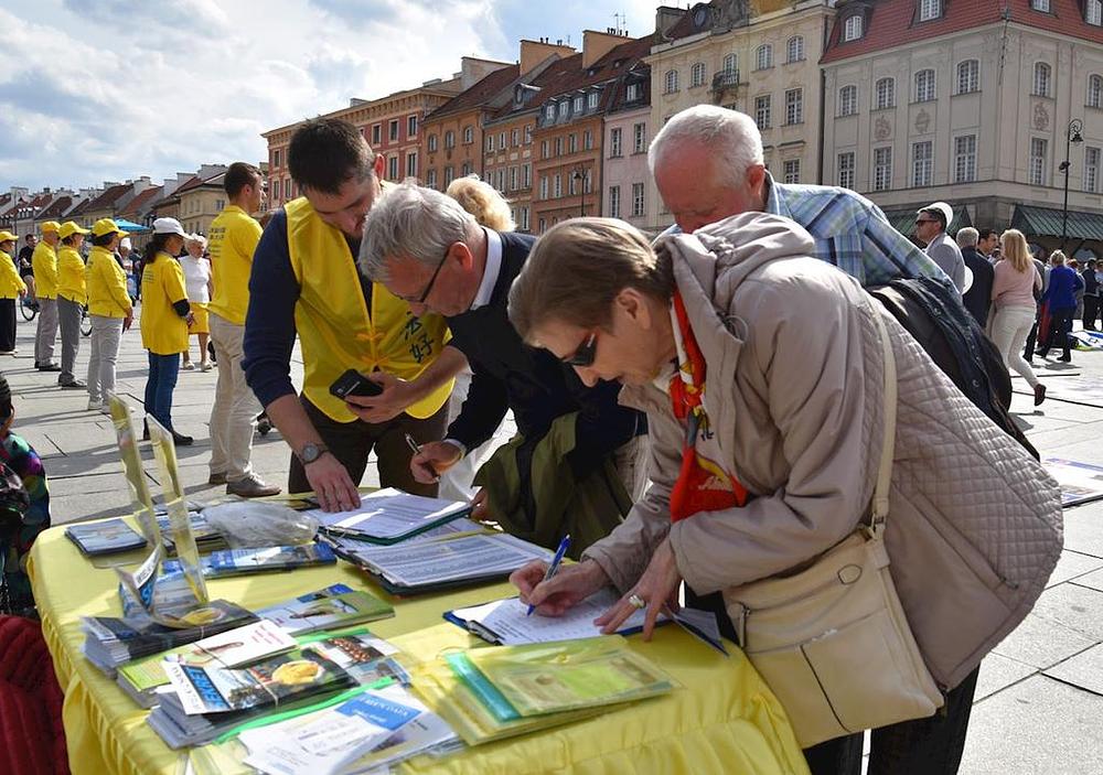 Turisti potpisuju peticiju praktikanata o osudi progona Falun Gonga kojeg provodi Komunistička partije Kine.