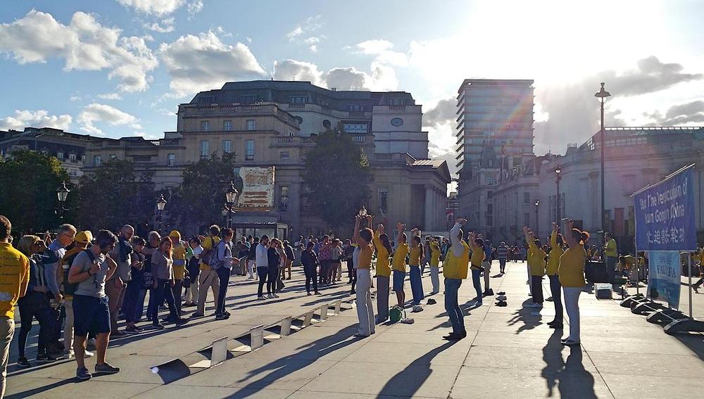 Praktikanti demonstriraju pokrete vježbi na trgu Trafalgar i informiraju prolaznike o progonu prakse u Kini
 
