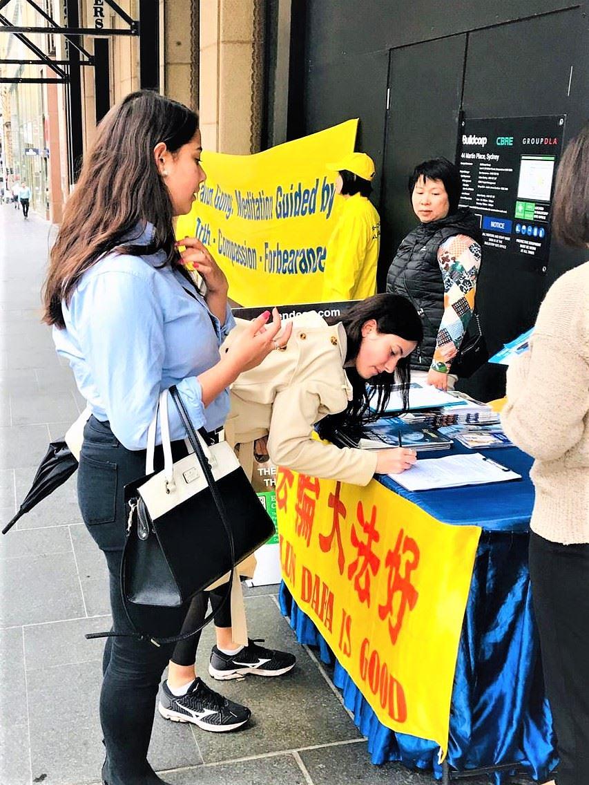 Nekoliko se prolaznika zaustavilo kako bi saznali više o Falun Dafa i potpisali peticiju
 