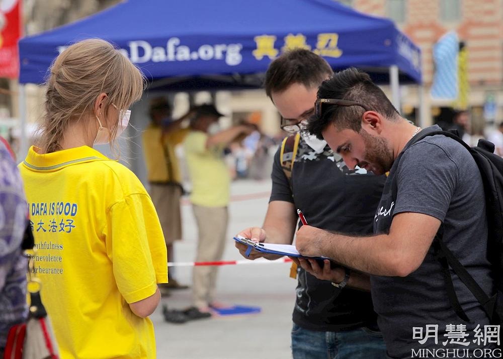 Prolaznici potpisuju peticiju kojom se osuđuje progon Falun Dafa od strane KPK.