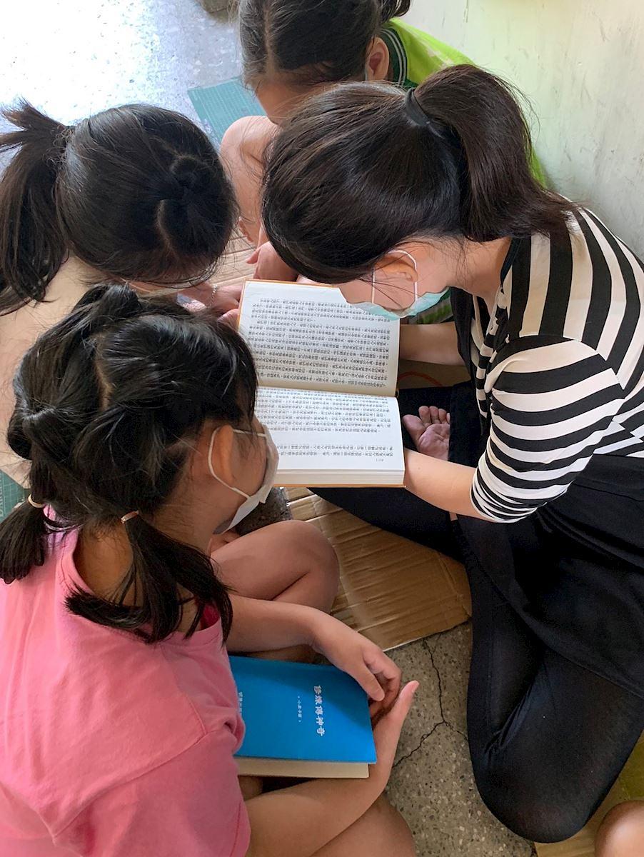 Gospođa Yu Qing čita Zhuan Falun i druge knjige o tradicionalnoj kulturi dok učenici slušaju.
 