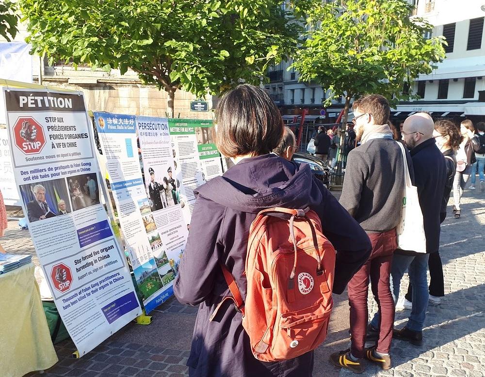 Prolaznici staju da pročitaju informacije o Falun Dafi na Chatelet Les Halles.