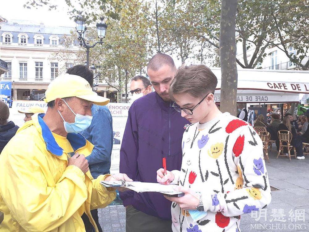 Mladi učenik potpisuje peticiju kojom se poziva na prekid progona Falun Dafe u Kini.