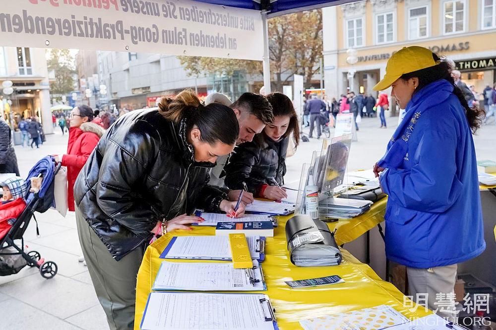 Prolaznici su saznali za progon Falun Dafa u Kini i potpisali peticiju za okončanje progona.