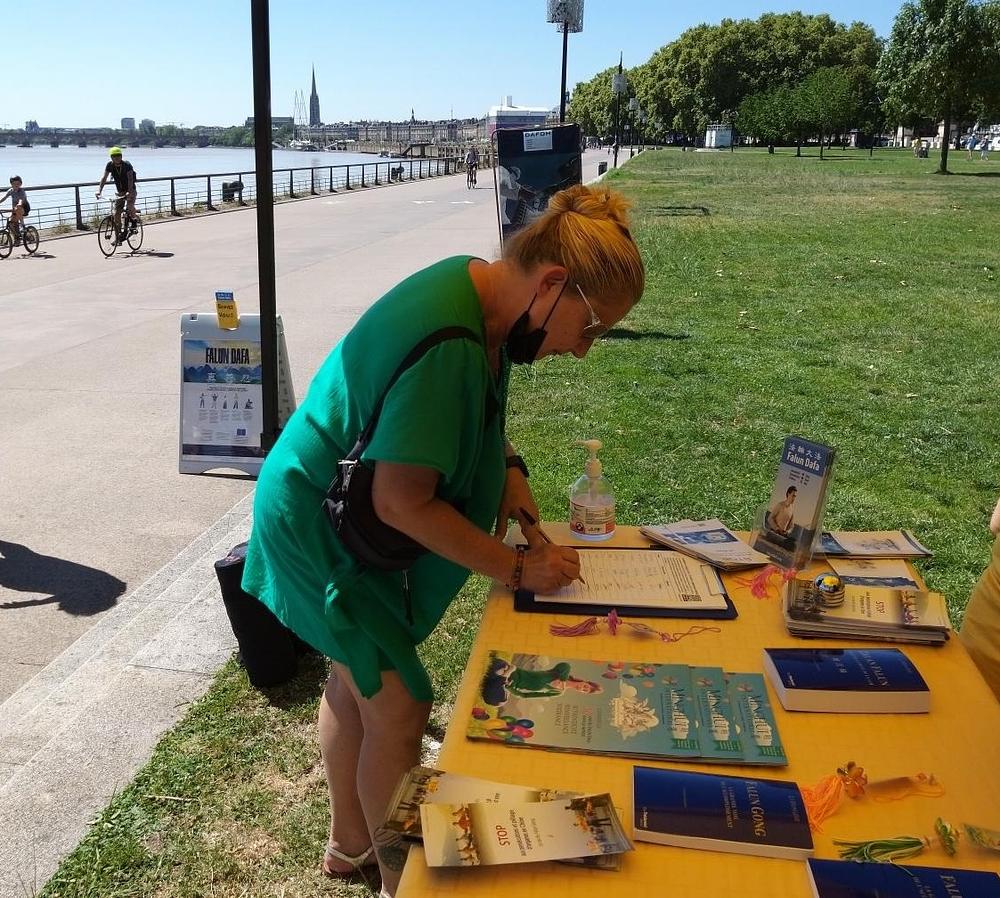 Ljudi su potpisali peticiju koja poziva na prekid progona Falun Dafa od strane KPK, tijekom skupova održanih na rijeci La Garonne 24. srpnja 2022.