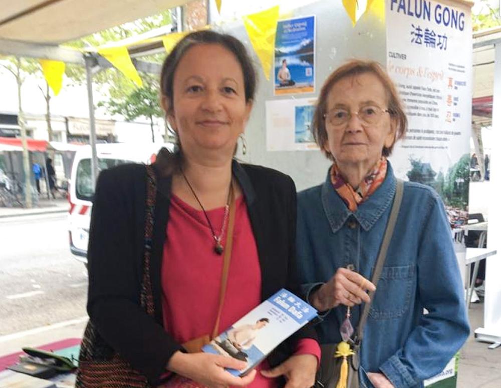 Dvije turistkinje rado primaju informacije o Falun Dafa