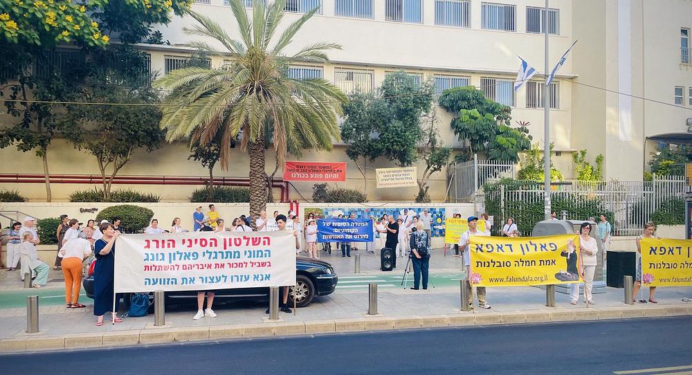 Praktikanti su, 20. jula 2023., držali transparente na hebrejskom sa informacijama o progonu u blizini kineske ambasade u Tel Avivu