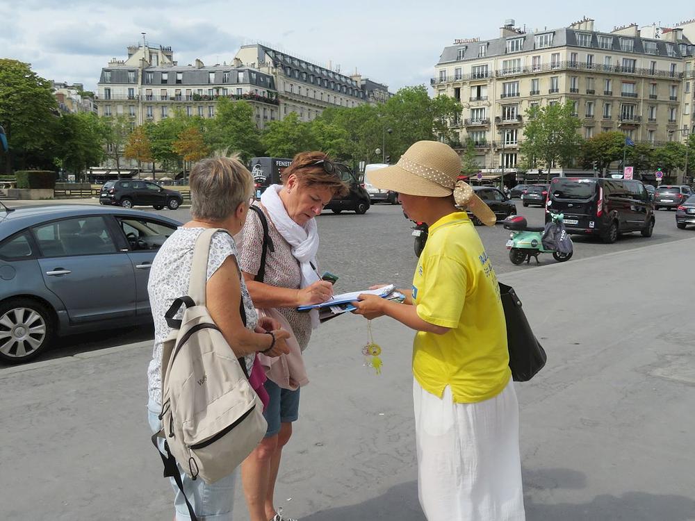  Falun Gong praktikanti u Parizu. Vježbanje je privuklo pažnju građana i turista koji su tražili više informacija. 