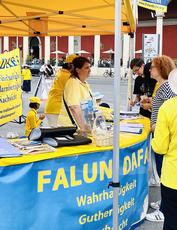Bivša poslanica Margarete Bause (desno) razgovara sa Falun Dafa praktikanticom.