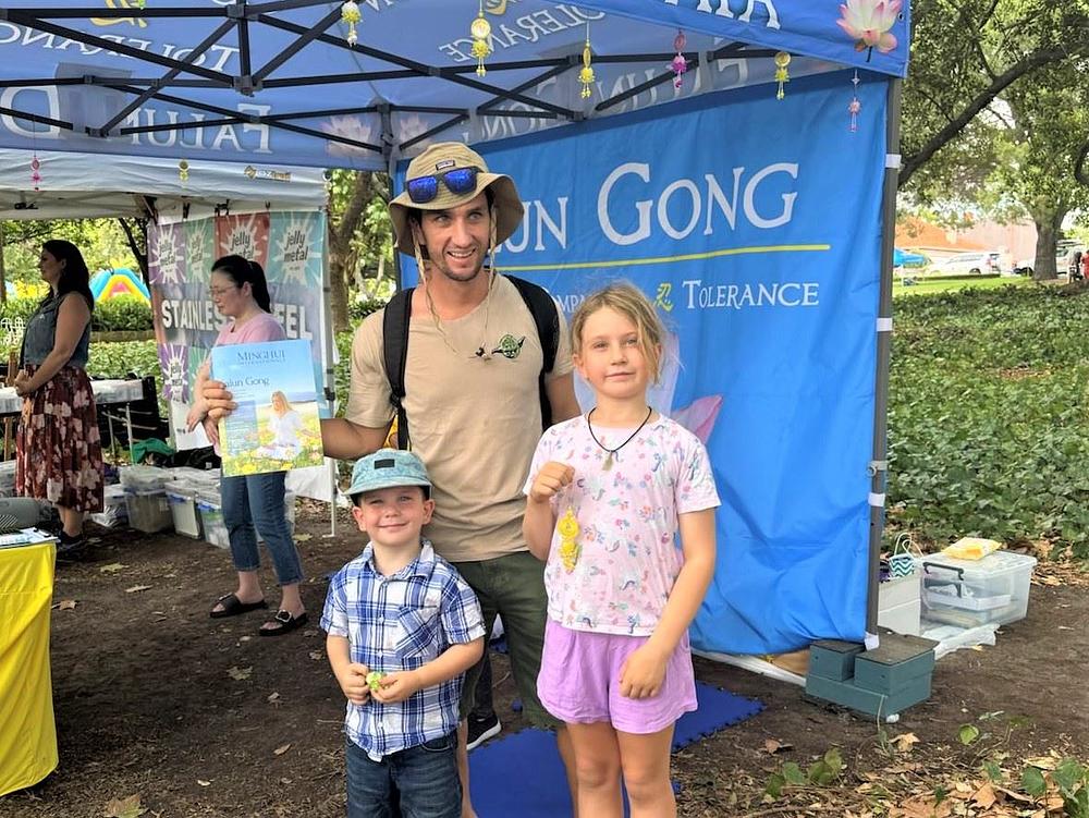Jonathan Gouvignon (u sredini) doveo je svoje dvoje djece na Falun Dafa štand.