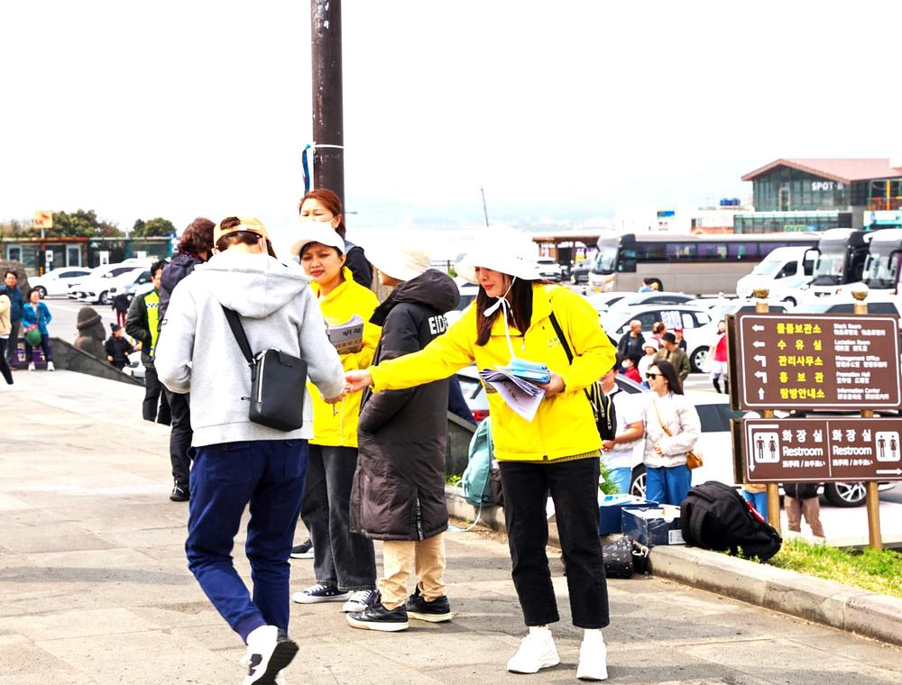  Turisti dobijaju Falun Dafa materijale.
