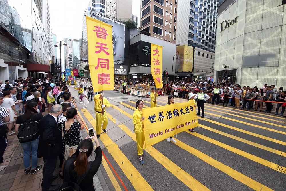 Turisti i stanovnici Hong Konga snimaju i slikaju veliku paradu Falun Gong praktikanata.