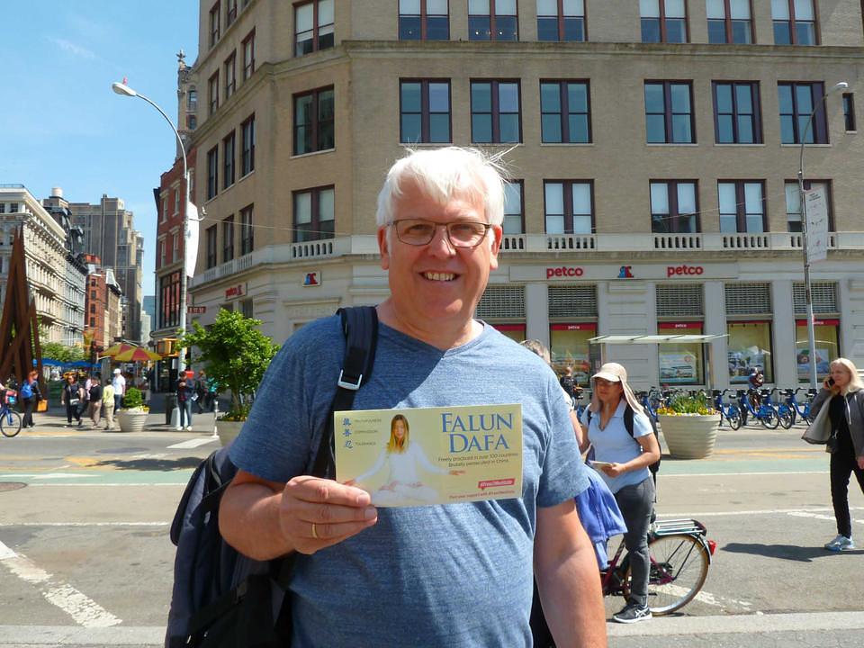 John, turist iz Belgije, je zamolio jednog praktikanta da napravi njegovu fotografiju kako drži informativni Falun Gong letak. Kazao je da će tu sliku staviti na svoju ličnu internet stranicu u znak podrške Falun Gongu.