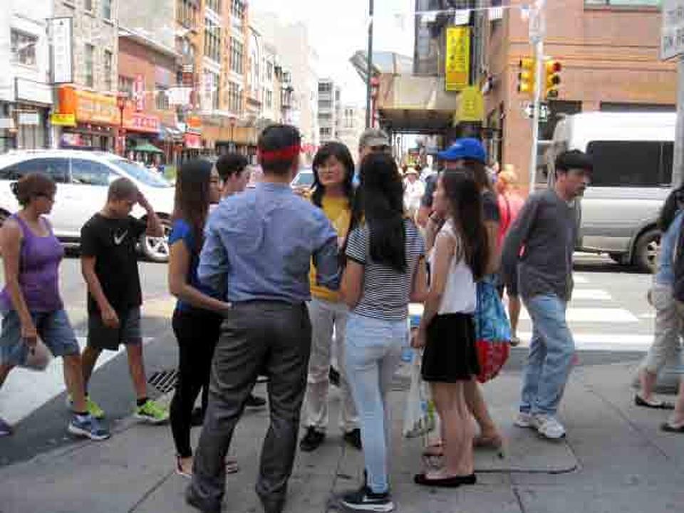 Praktikantica Falun Gonga (na slici u sredini, u žutoj odjeći) razgovara sa prolaznicima o progonu.