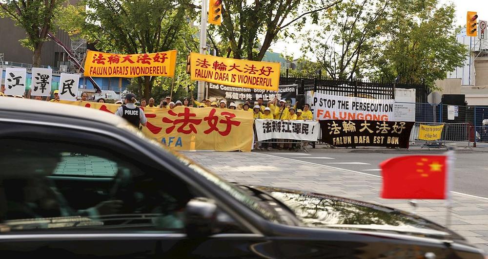 Povorka automobila sa Li Keiqiangom prolazi ispred transparenata istaknutih ispred hotela Westin 