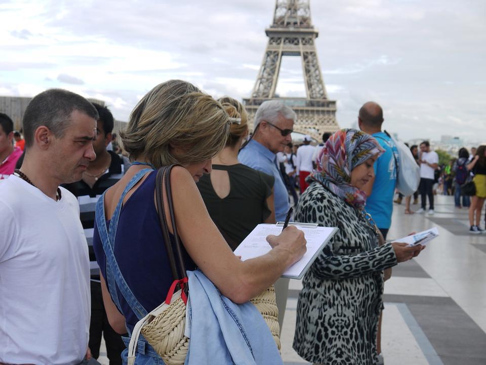Turisti čitaju Falun Gong materijale i potpisuju peticiju 11. septembra.