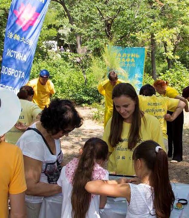 Ljudmila (sa dugom kosom i u žutoj majici) na Falun Dafa manifestaciji.