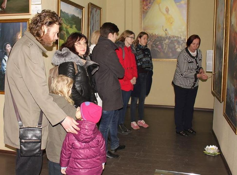 Posjetioci razgledaju umjetničke radove i saznaju priče koje stoje iza ovih slika.