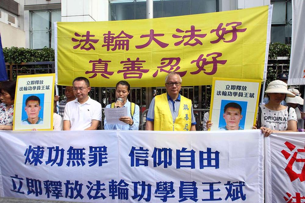 Praktikanti Falun Gonga održavaju skup ispred Kineskog ureda za vezu u Hong Kongu 30. maja 2017. godine. Na transparentu koji se nalazi na vrhu je napisano: „Falun Dafa je dobar, Istinitost-Dobrodušnost-Tolerancija su dobri.“ Na donjem transparentu je napisano: „Sloboda vjerovanja. Odmah oslobodite praktikanta Falun Gonga Wang Bina.“