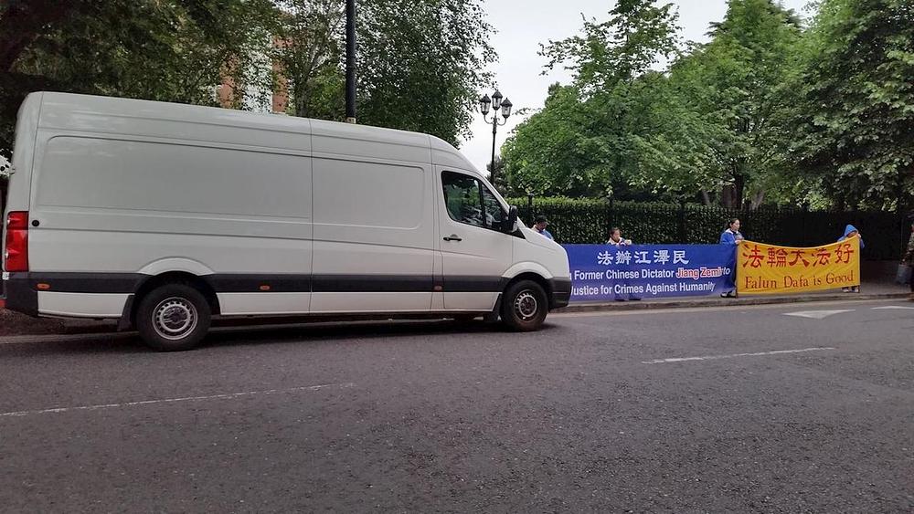 Kineska ambasada koristi automobile za blokadu pogleda na transparente, pokušavajući tako onemogućiti prolaznicima i vozačima da vide proteste.