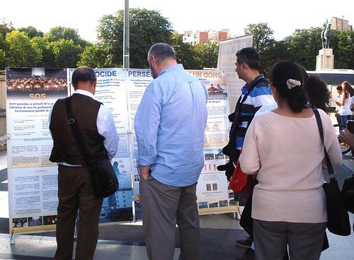 Prolaznici čitaju informacije o Falun Gongu na Trgu ljudskih prava