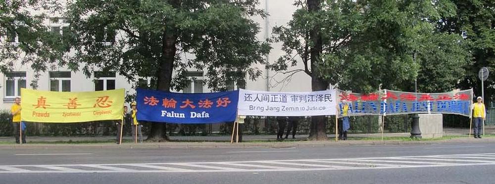 Praktikanti Falun Gonga drže transparente ispred hotela Regent u kojem su se sastali kineski i poljski zvaničnici 