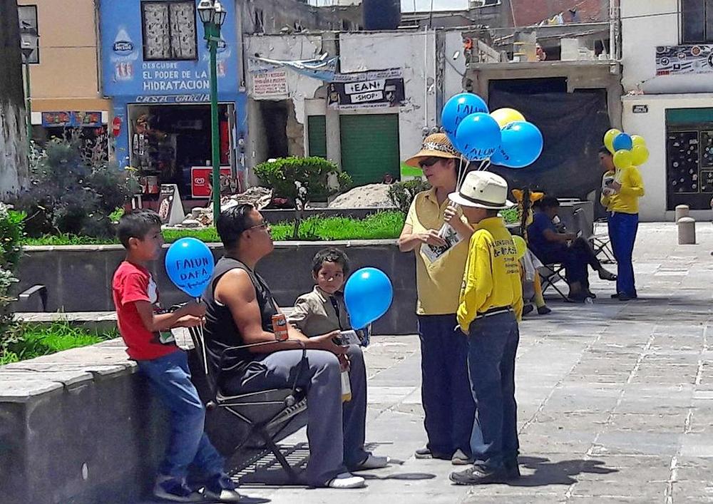 Majka i sin praktikanti razgovaraju sa ljudima u Tlaxcalau o progonu u Kini.