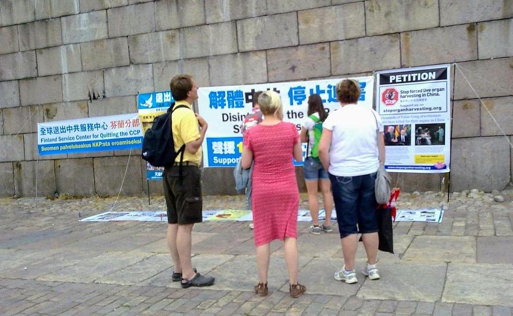 Turisti čitaju postere na trgu Senata 