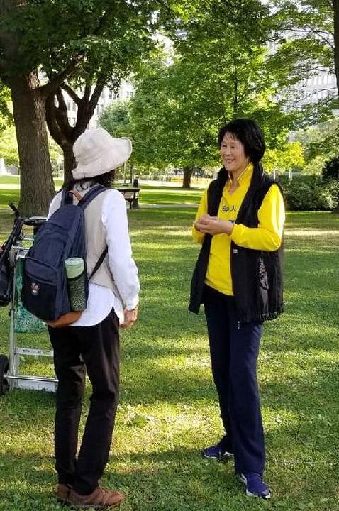 Falun Gong praktikantica razgovara sa turistkinjom iz Kine 