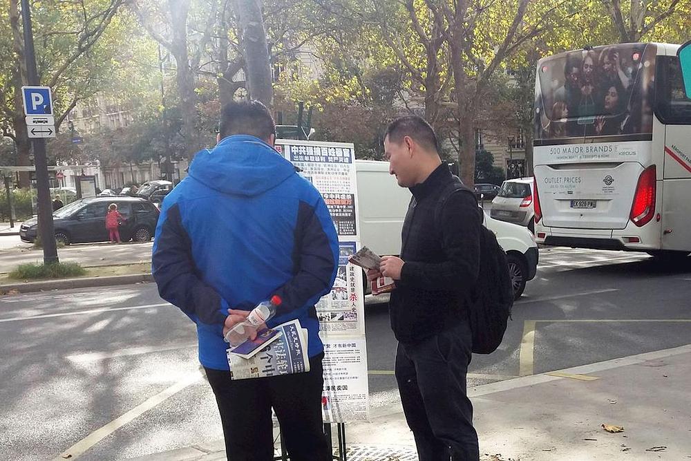 Turisti iz Kine gledaju Falun Gong materijale 