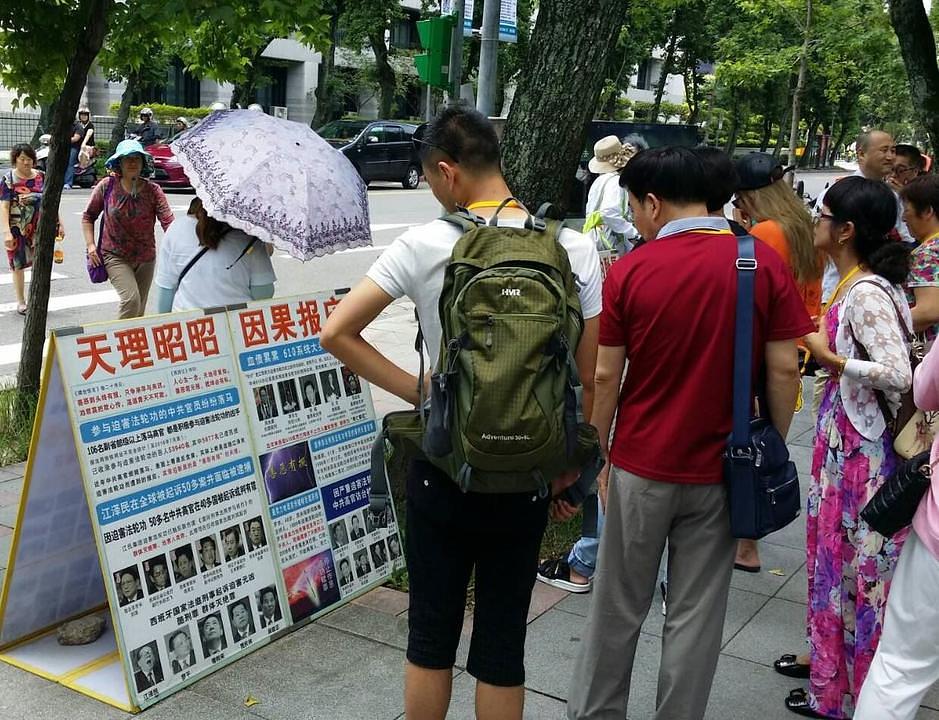  Kineski turisti čitaju plakate koje su izložili praktikanti Falun Gonga ispred memorijalne dvorane dr. Sun Yat-sen u Taipeiju. 
 