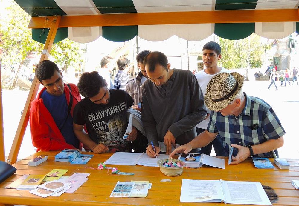 Građani potpisuju peticiju na Falun Gong štandu. 