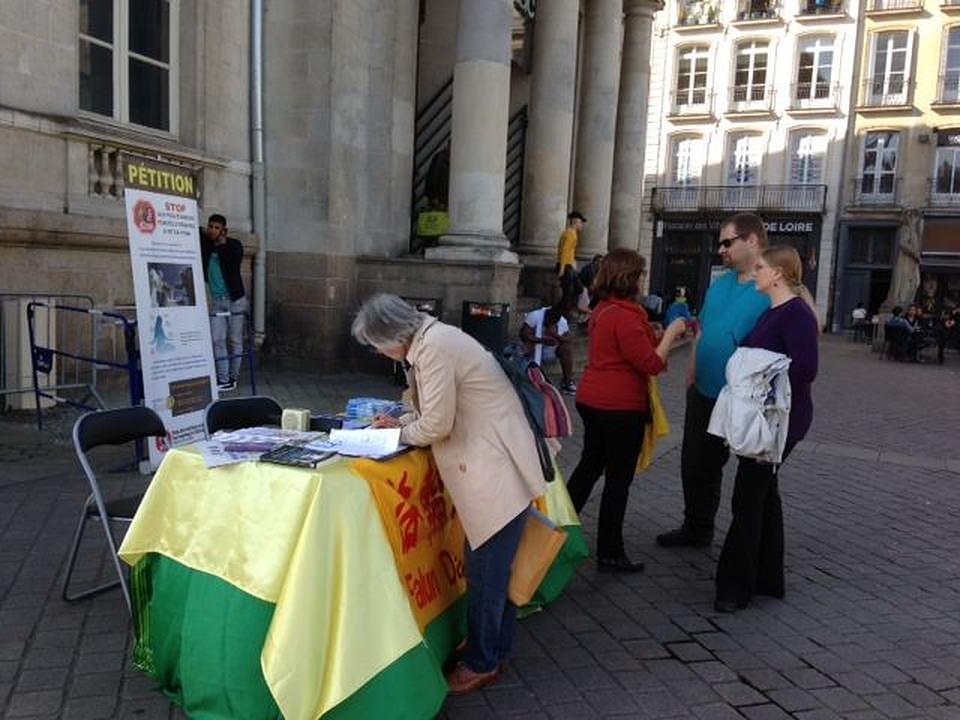 Informiranje posjetitelja o nasilnoj žetvi organa u Kini (desno). Potpisivanje peticije u svrhu osude zločina. 