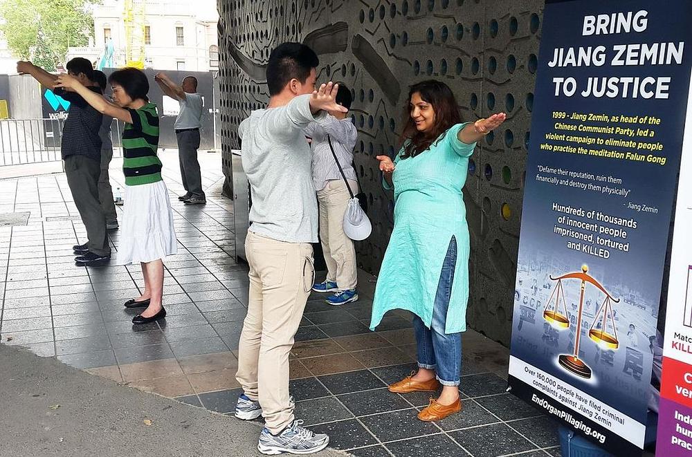 Natalie Lauren (u sredini) i njen suprug su 2. decembra u Parramatti razgovarali s praktikantom. Željeli su naučiti Falun Dafa vježbe.