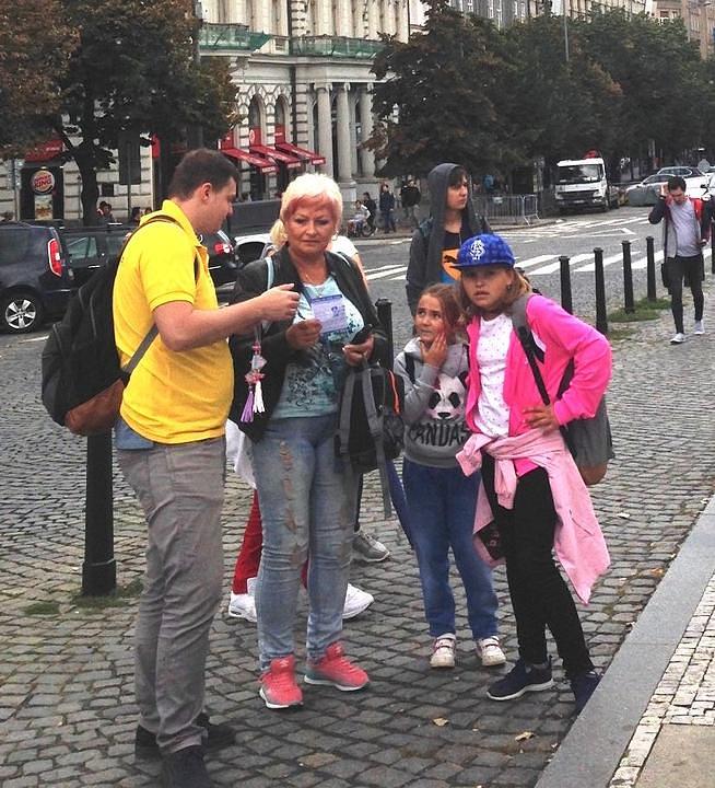 Prolaznici čitaju postere i slušaju praktikante kako im govore činjenice o progonu Falun Gonga.
