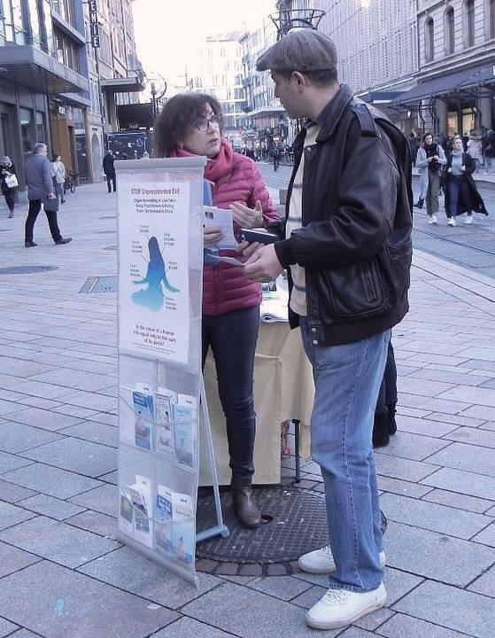 Praktikanti prolaznicima objašnjavaju Falun Dafa.