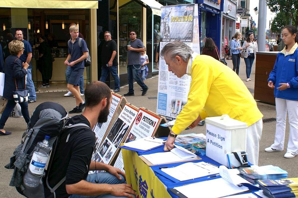 Prolaznici dobivaju informacije o Falun Gongu i razgovaraju sa praktikantima.