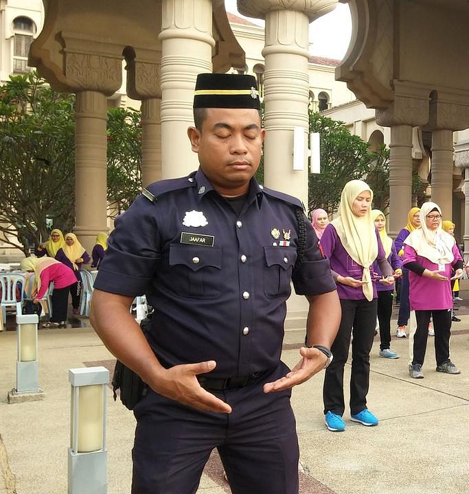 Gospodin  Jaafar (prvi sa lijeve strane), čuvar državne kancelarije, uči Falun Gong