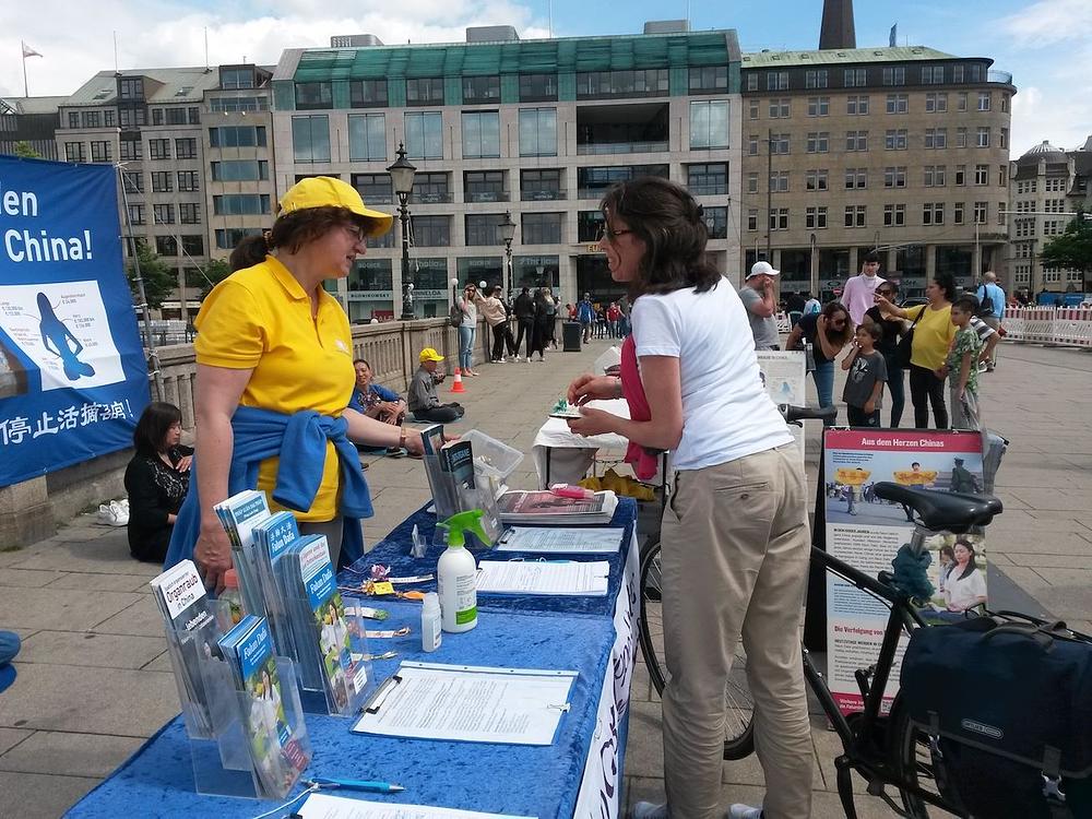 Žena potpisuje peticiju i dobiva origami cvijet lotosa.