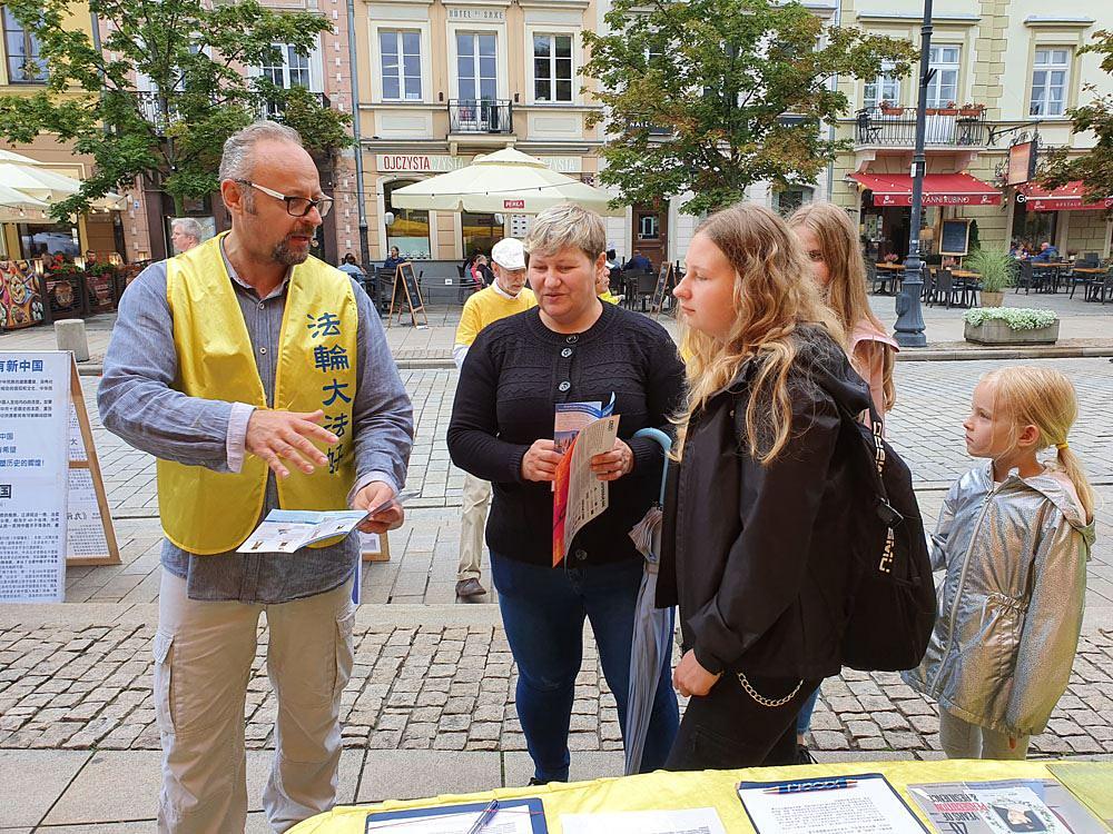 Prolaznici se zaustavljaju kod Falun Gong štanda