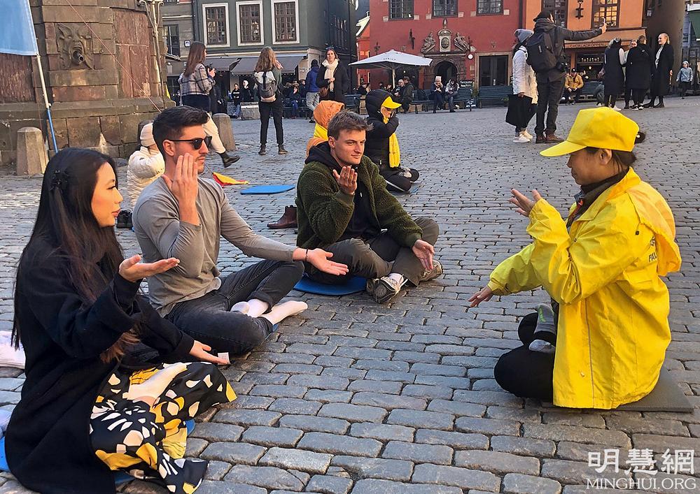 Ljudi uče vežbe Falun Dafe.