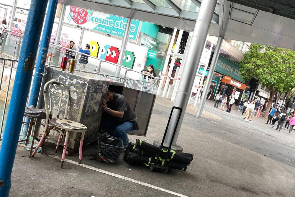 Muškarac vadi plakate iz metalne kutije u vlasništvu HKYCA.